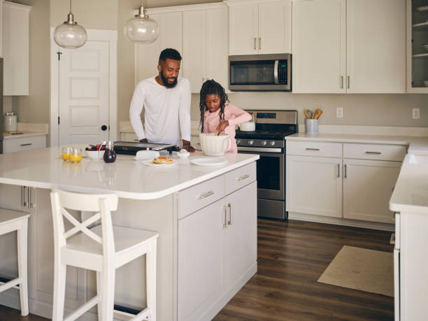 istock Father and Daughter Cooking and Eating a Pancake Breakfast 1569802339