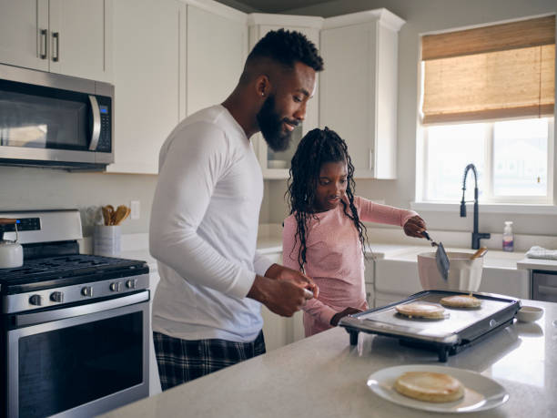 istock Father and Daughter Cooking and Eating a Pancake Breakfast 1569804444