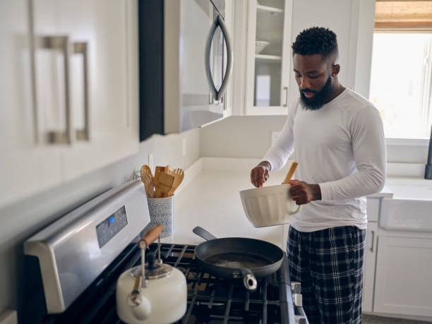 istock Man Cooking and Eating a Pancake Breakfast 1569804466