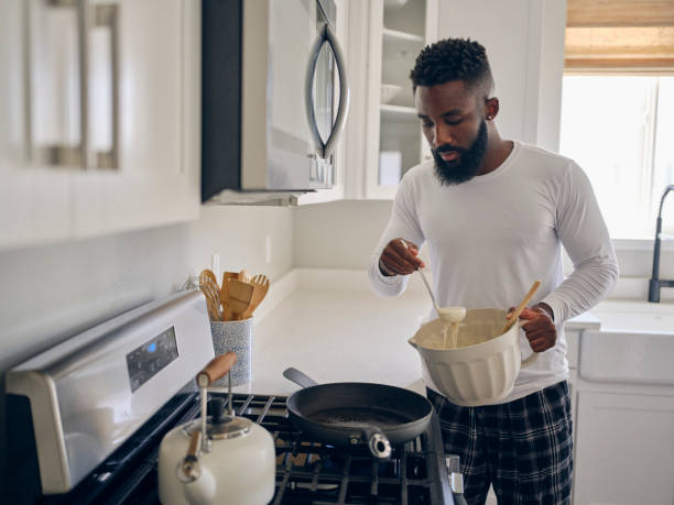 istock Man Cooking and Eating a Pancake Breakfast 1569804562