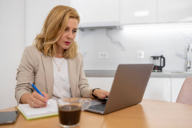istock Business woman using laptop and a notebook 1569809377
