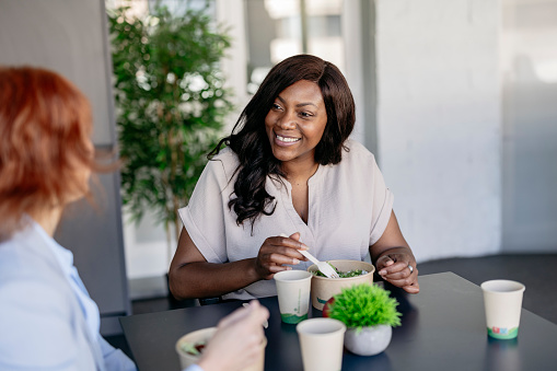 multiracial businesswomen having breakfast in cafeteria