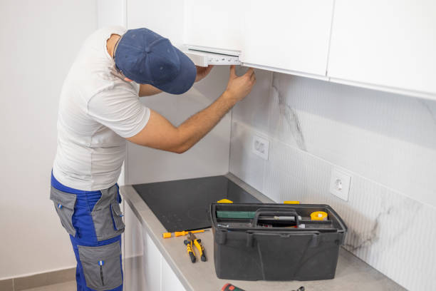 istock Man climbing in the kitchen in order to fix the aspirator 1569818659