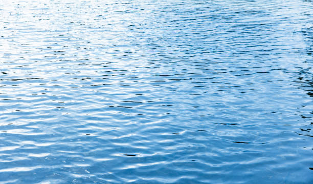 istock Shiny water surface with reflections of blue sky, abstract photo 1569835903