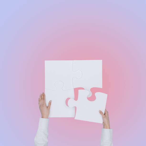istock Business person solving a jigsaw puzzle 1569847413
