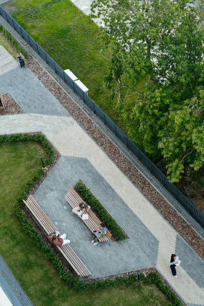 istock High angle of park with green grass and trees, grey pathways and rest zone 1569853367
