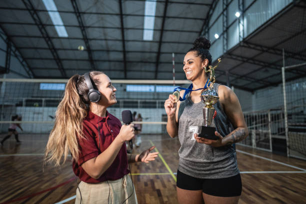 młoda reporterka telewizyjna przeprowadza wywiad z siatkarką po wygraniu meczu na boisku sportowym - medal 20s achievement athlete zdjęcia i obrazy z banku zdjęć