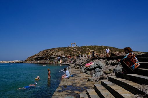 People enjoy the sun and swim on the seafront of Naxos, Greece on July 10, 2023.