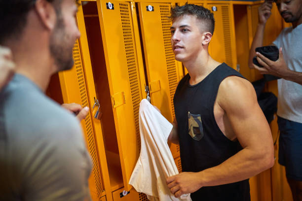 istock Young men in the locker room, having a conversation together before working out. 1569895607