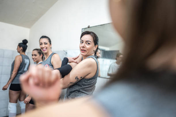 istock Female volleyball team stretching while talk in the locker room 1569896705