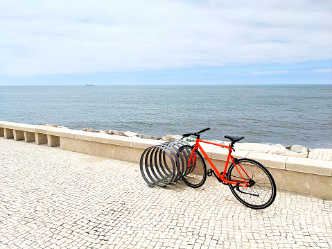 Red bycicle at the parking space on the ocean beach. Figueira da Foz, Portugal