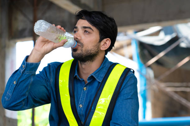 istock construction worker drinking water from bottle due to tired hard work and thirst 1569906304