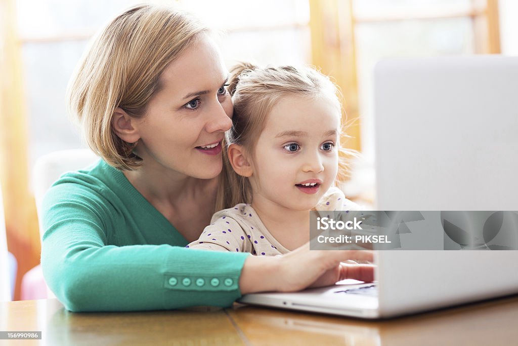 Daughter and mother looking at a laptop Adult Stock Photo