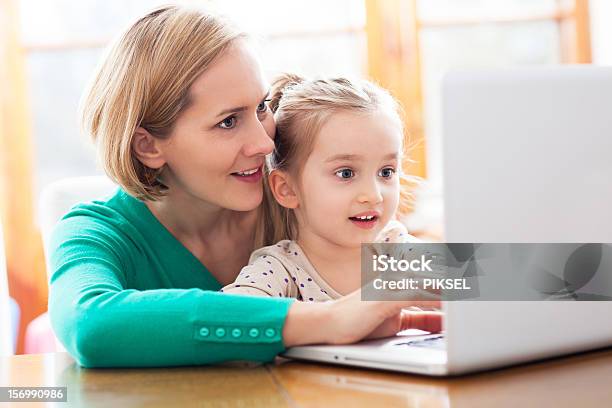 Daughter And Mother Looking At A Laptop Stock Photo - Download Image Now - Adult, Child, Childhood