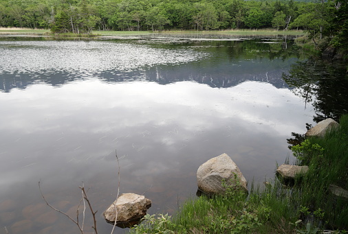 Reflections of the Shiretoko Mountains on the surface of Lake Niko or Second Lake. Spring afternoon in Shiretoko National Park in eastern Hokkaido.