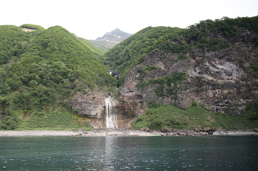 Spring afternoon at the Kamuiwakka Falls in Shiretoko National Park. Background shows the Shiretoko Mountains.
