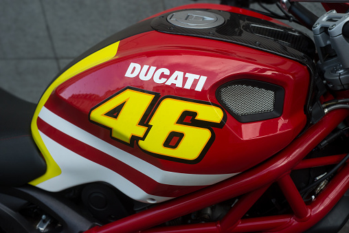 Mulhouse - France - 25 July 2023 - Closeup of Ducati logo on red tank of motorbike parked in the street