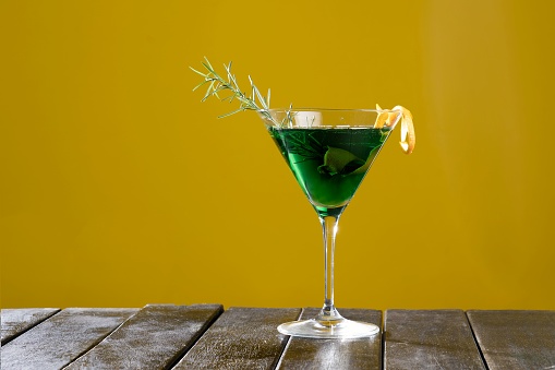 A refreshing green beverage served in a glass on a wooden table, ready to be enjoyed