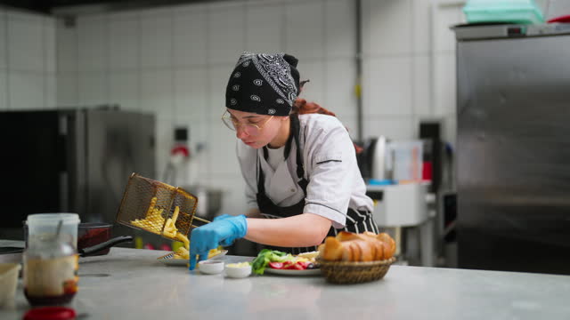 Woman working and preparing food in commercial kitchen