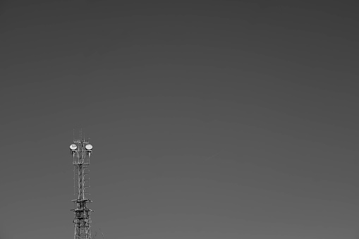 Lone utility tower and totally clear sky in black and white