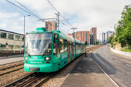 Sheffield, UK - A tram moving downhill between public roads just outside Sheffield's city centre.