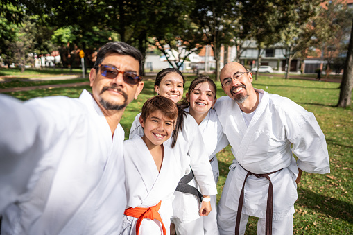 Karate/taekwondo students taking a selfie at public park - Camera point of view