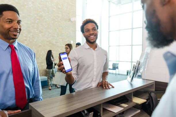 istock Dad smiles as son asks banker about mobile app 1569974279