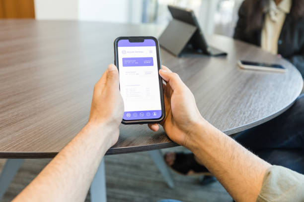 istock View man holding phone showing mobile app 1569975336