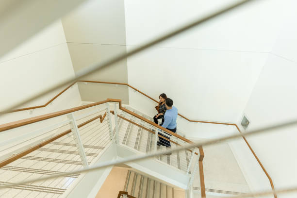 istock High angle view couple walking up stairs to meeting 1569975355
