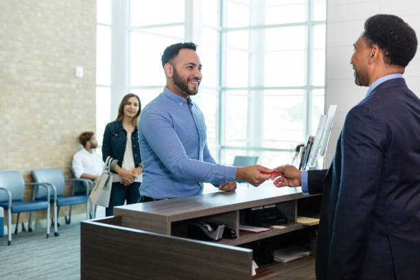 istock Banker and businessman exchange pleasantries during transaction 1569975543