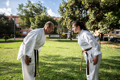 Karate/taekwondo students bowing during class at public park