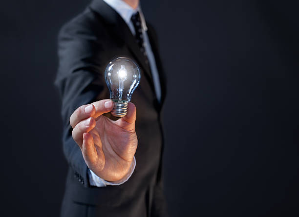 istock New business man idea: male manager holding a light bulb 156999364