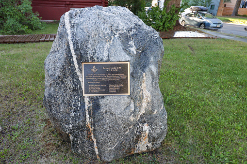 Time Capsule at Jackson 48 Masonic Lodge on Snow King Street in Jackson (Jackson Hole) at Teton County, Wyoming. Here, in 2014, on the 100th anniversary of the town of Jackson, His Most Worshipful Grand Master of the Wyoming Grand Lodge of Freemasons Richard Lewis poured wine on this boulder outside Jackson Lodge. Inside the boulder is a time capsule which will be opened in the year 2114 where people will find memorabilia that was placed inside in 2014. Several names are visible on the plaque.