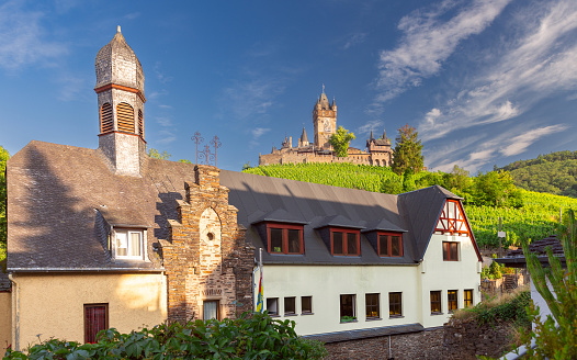 Medieval European fortress Reichsburg on a hill with vineyards on a sunny day. Cochem, Germany.