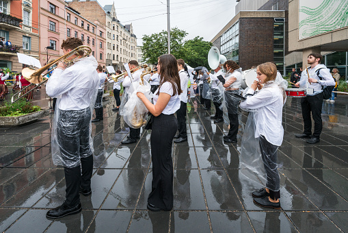 Riga, Latvia - June 2, 2023: The youth orchestra plays in the rain