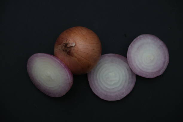 istock Onion slices on black background , top view 1570008525