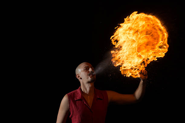 istock Street Performer Fire Breather Blowing on Torch 157001924