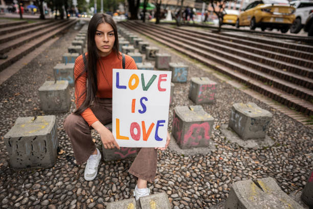 porträt eines teenager-mädchens, das ein banner hält, das die lgbt-bewegung im freien unterstützt - women placard teenage girls student stock-fotos und bilder