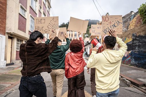 Young protesters holding banners on a demonstration against violence outdoors