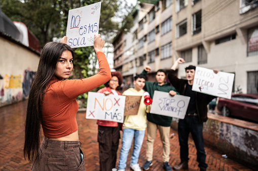 Portrait of a teenage girl holding a banner on a demonstration outdoors