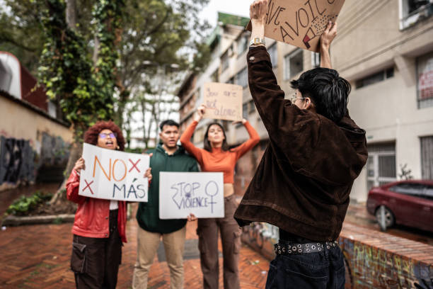 istock Young protesters holding banner against violence on demonstration outdoors 1570023740