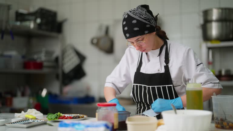 Woman working and preparing food in commercial kitchen