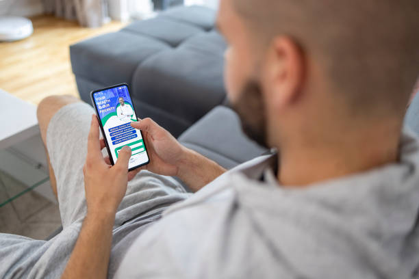 istock Man holding phone with online medical app on screen 1570044568