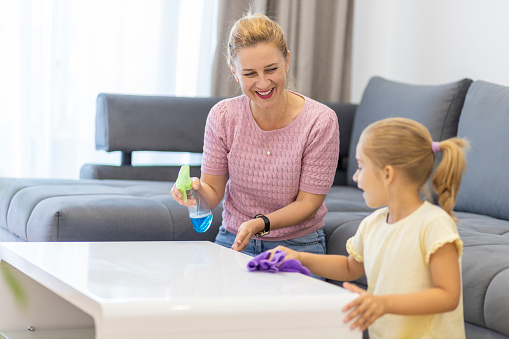 Mother and daughter smiling when cleaning