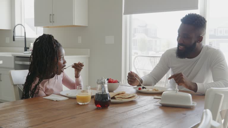 Father and Daughter Cooking and Eating a Pancake Breakfast