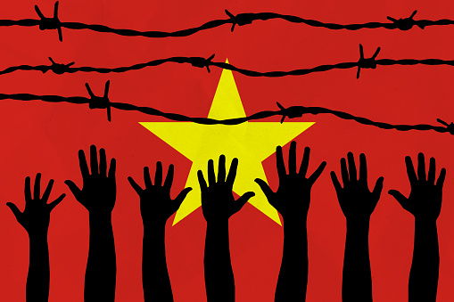 Vietnam flag behind barbed wire fence. Group of people hands. Freedom and propaganda concept