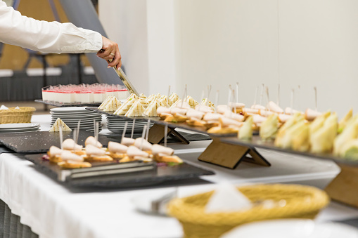 Business breakfast for conference participants. All inclusive breakfast at the hotel. Woman's hand takes a sandwich