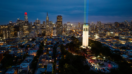 San Francisco, CA, USA - July 16, 2023:  Coit Tower 90th Anniversary laser light show installation  lit up the San Francisco night sky with eight lasers beaming towards the heavens.