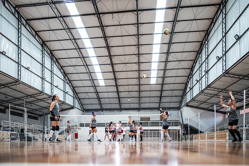 Female volleyball players playing a volleyball match on the sports court