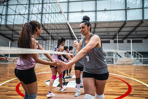 Female volleyball teams greeting each other before the match on the sports court